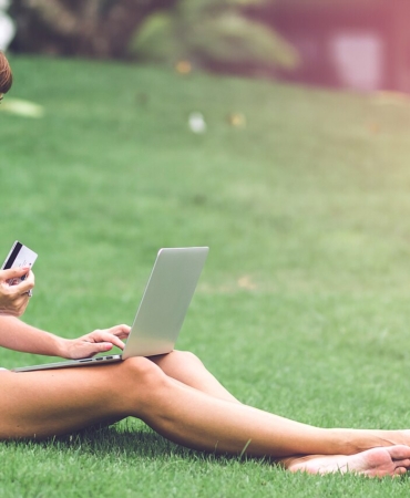 Dizüstü bilgisayarla internetten alışveriş yapan kişi