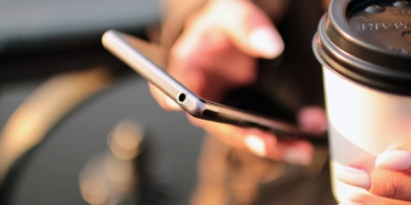Kahve yanında telefon kullanan eller