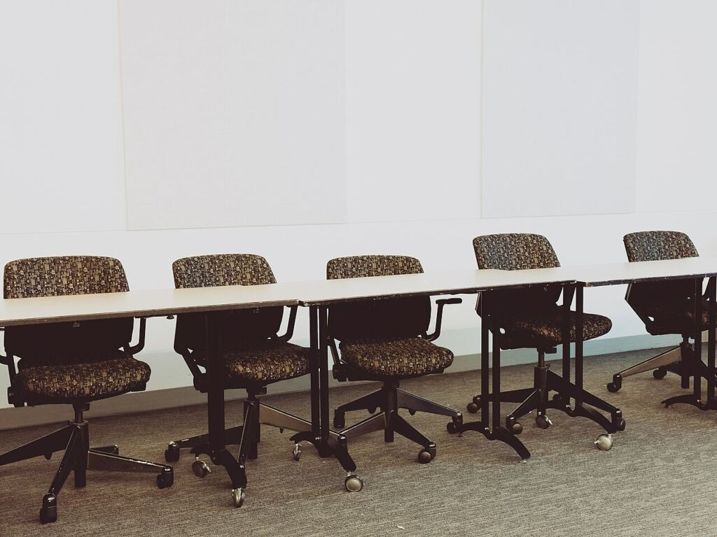 Uzun bir toplantı masası etrafındaki ofis sandalyeleri