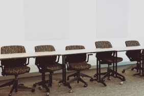 Uzun bir toplantı masası etrafındaki ofis sandalyeleri